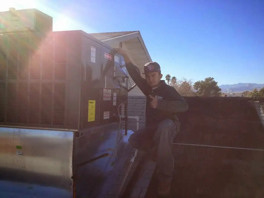HVAC technician performing Heat Pump Repair on a rooftop unit in Dove Valley